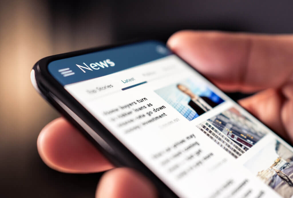 Consultation d’un article de presse sur un smartphone, symbolisant la rédaction de contenus web.
